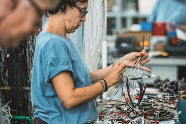 operaia ades districa e unisce cavi e cablaggi